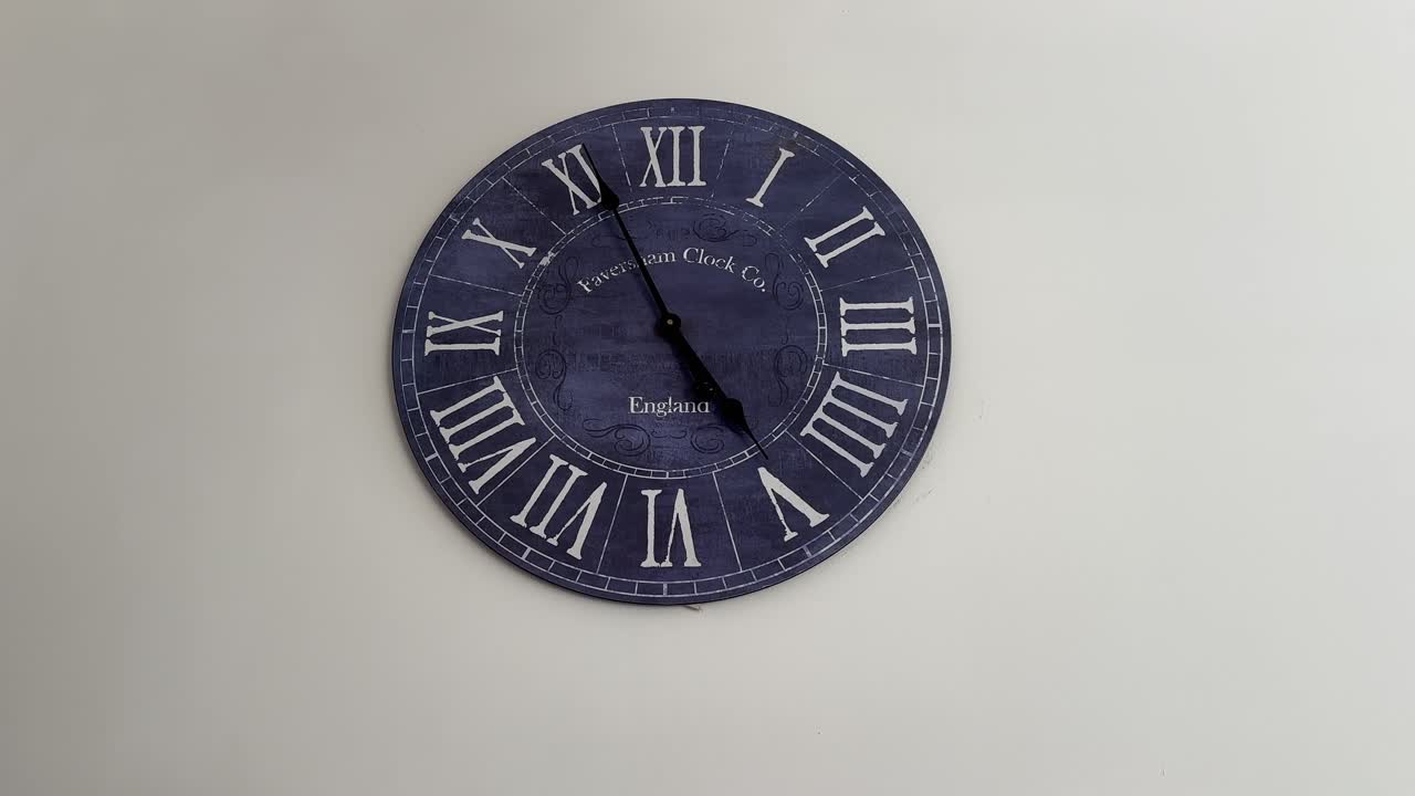 Close up shot of a blue big clock on the wall in the living room of a home england