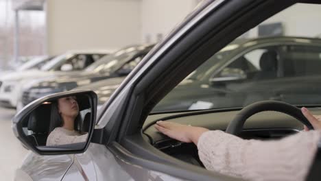 woman choosing a car in a car showroom