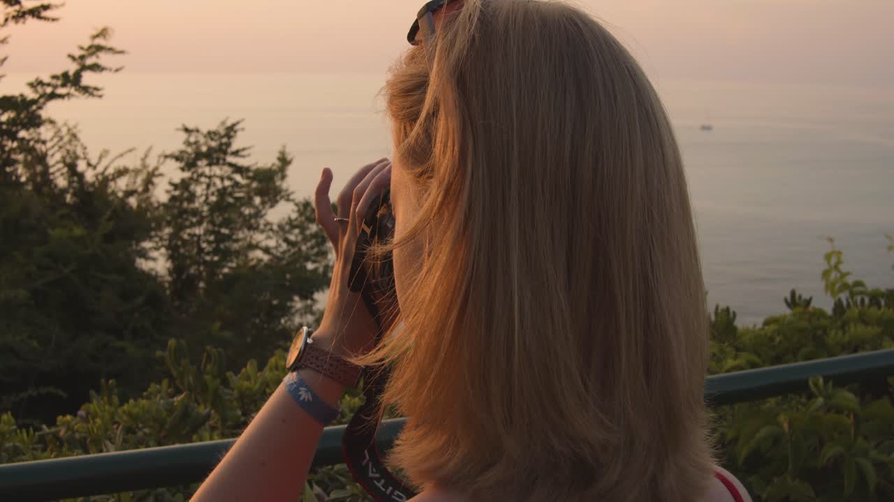Woman taking pictures from ocean-beach - evening - slow motion