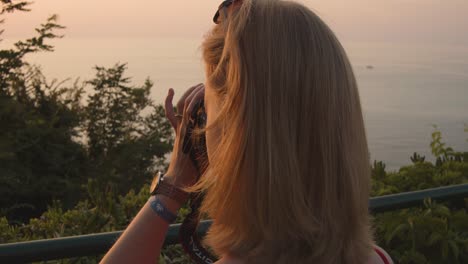 Woman-taking-pictures-from-ocean-beach---evening---slow-motion