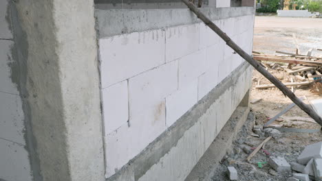 vista de bloques huecos recién colocados y algunos materiales de construcción en el suelo de una casa en construcción