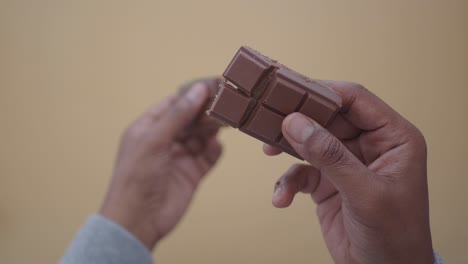 hands breaking a chocolate bar with green filling