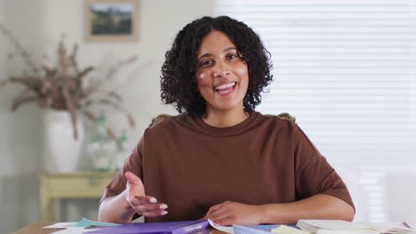 mujer biracial haciendo una videollamada de negocios en casa, hablando y gesticulando, cámara lenta