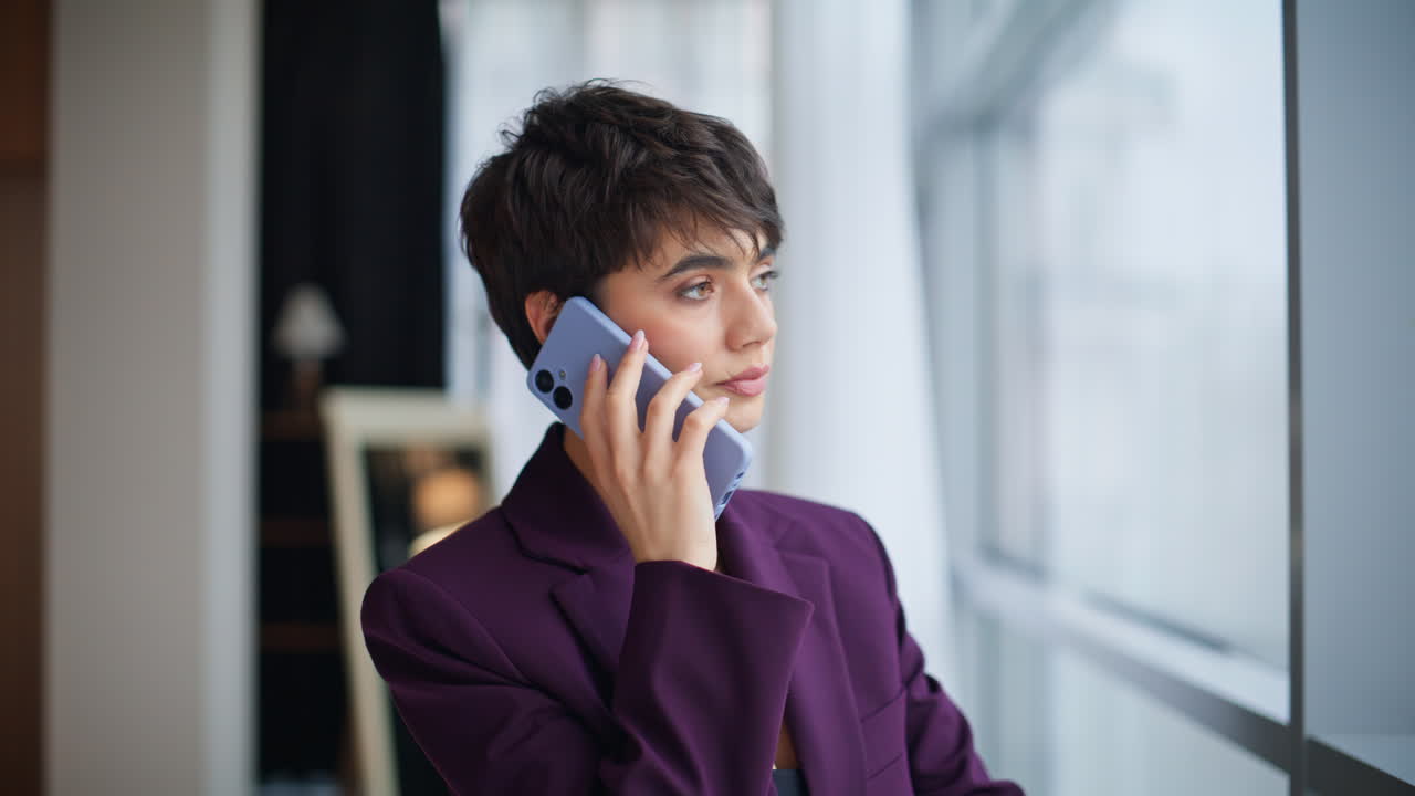 Closeup serious entrepreneur calling cellphone office window. Manager talking
