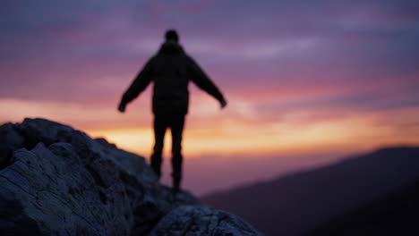 man on mountain top at sunrise/sunset