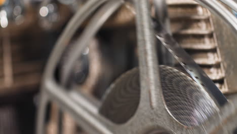 Macro close up of 8mm film strip tape spooling on to a reel from an old vintage analog 8mm projector