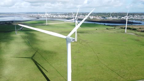 aerial view flying around renewable energy wind farm wind turbines spinning on british countryside slow right dolly