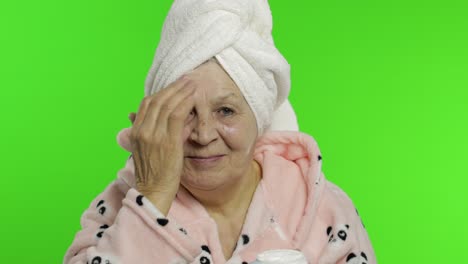 Abuela-Anciana-En-Bata-De-Baño.-Anciana-Aplicando-Crema-Hidratante-En-La-Cara.