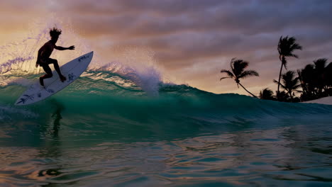 surfer riding a wave at sunset