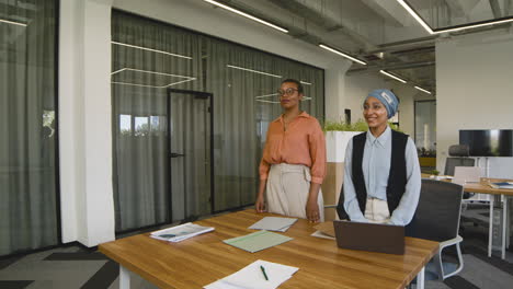 two and muslim businesswomen are waiting for a young man to do a job interview