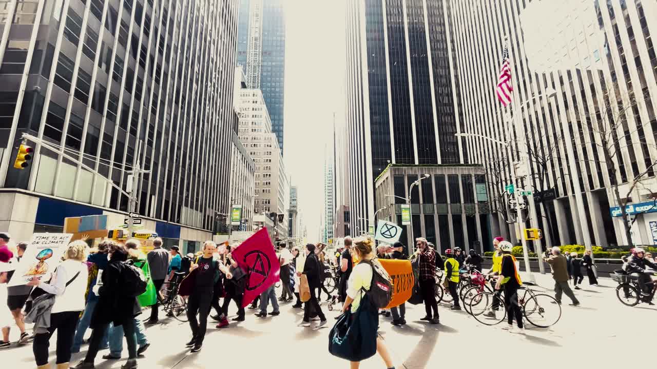 Large crowd of people walking by during an Extinction Rebellion protest march in the city centre of New York