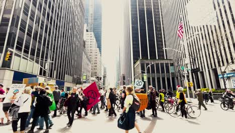 large crowd of people walking by during an extinction rebellion protest march in the city centre of new york