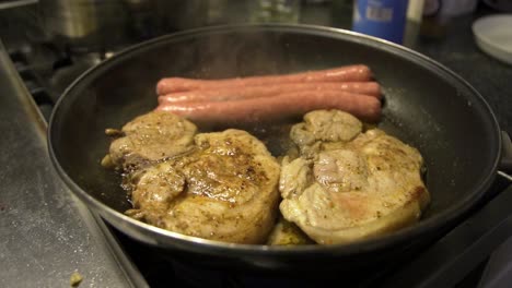 pan on kitchen stove, cooking meat in butter and garlic, sausages and smelt cutlets