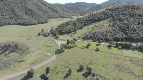 Utah-Hills-and-Mountains-in-the-Summer-with-Dirt-Road-and-Pond-Aerial-View-4K