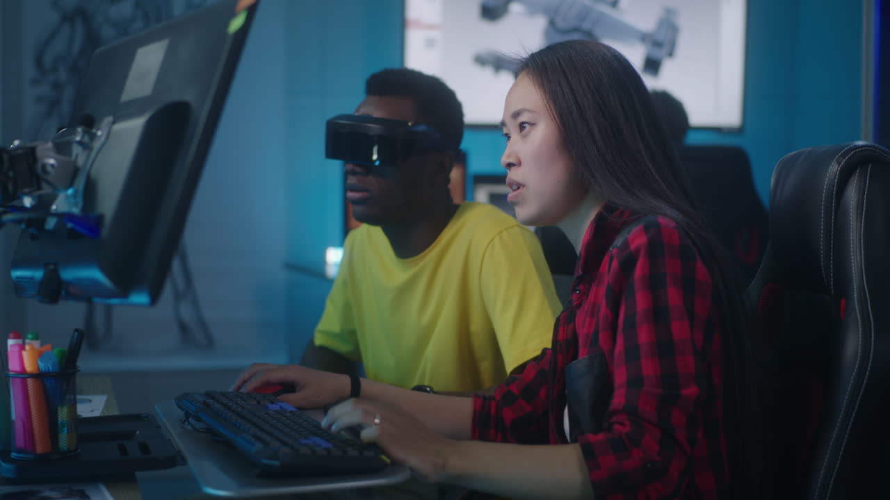 Two people working on a project in a computer lab with VR headsets
