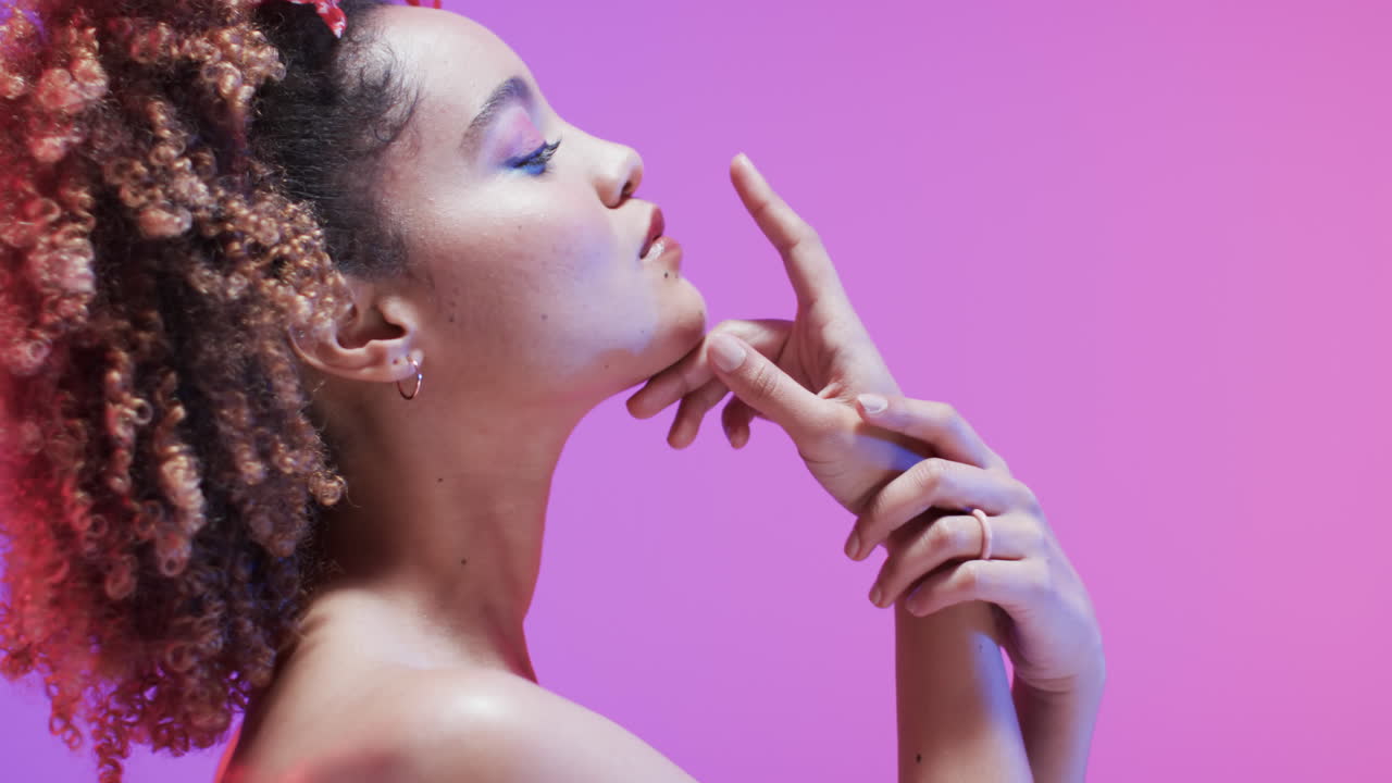 mujer biracial con cabello oscuro en luz azul y rosa con espacio de copia, cámara lenta