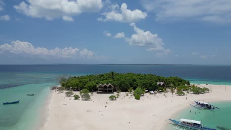 Aerial-rising-pullback-of-patawan-island,-tropical-green-jungle,-banca-boats