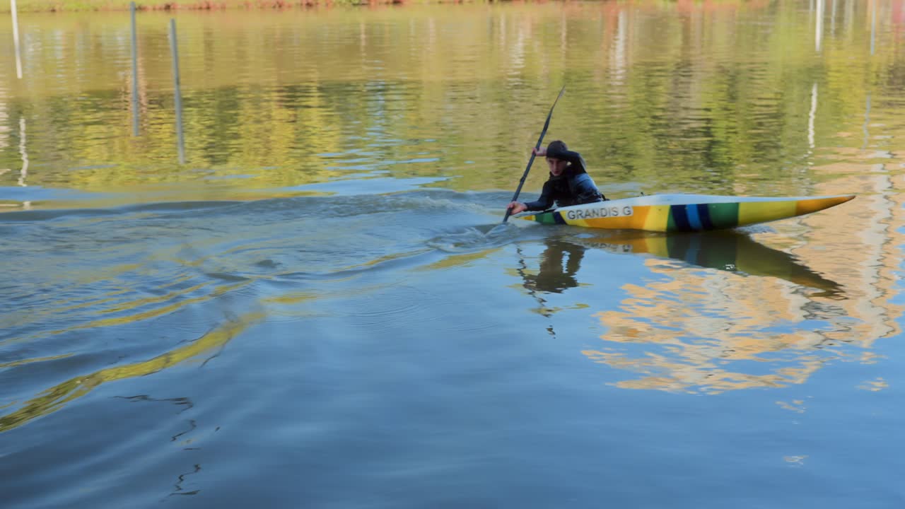 A person kayaking on a lake, showing a capsize and recovery