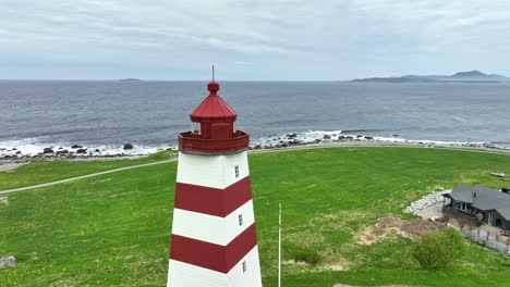 alnes lighthouse outside alesund norway - flying and rotating closely around top of lighthouse with atlantic ocean and horizon seen in background