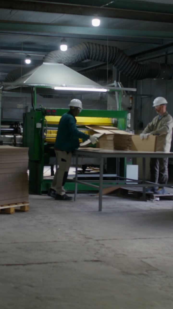 Workers operating woodworking machinery in a factory