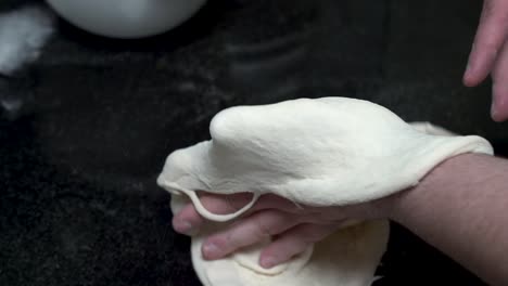 close up of hands kneading the dough to make pizza in slow motion