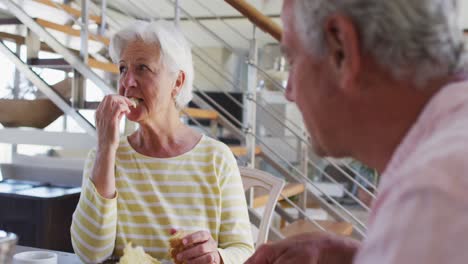 Senior-caucasian-couple-having-breakfast-together-talking-to-each-other-at-home