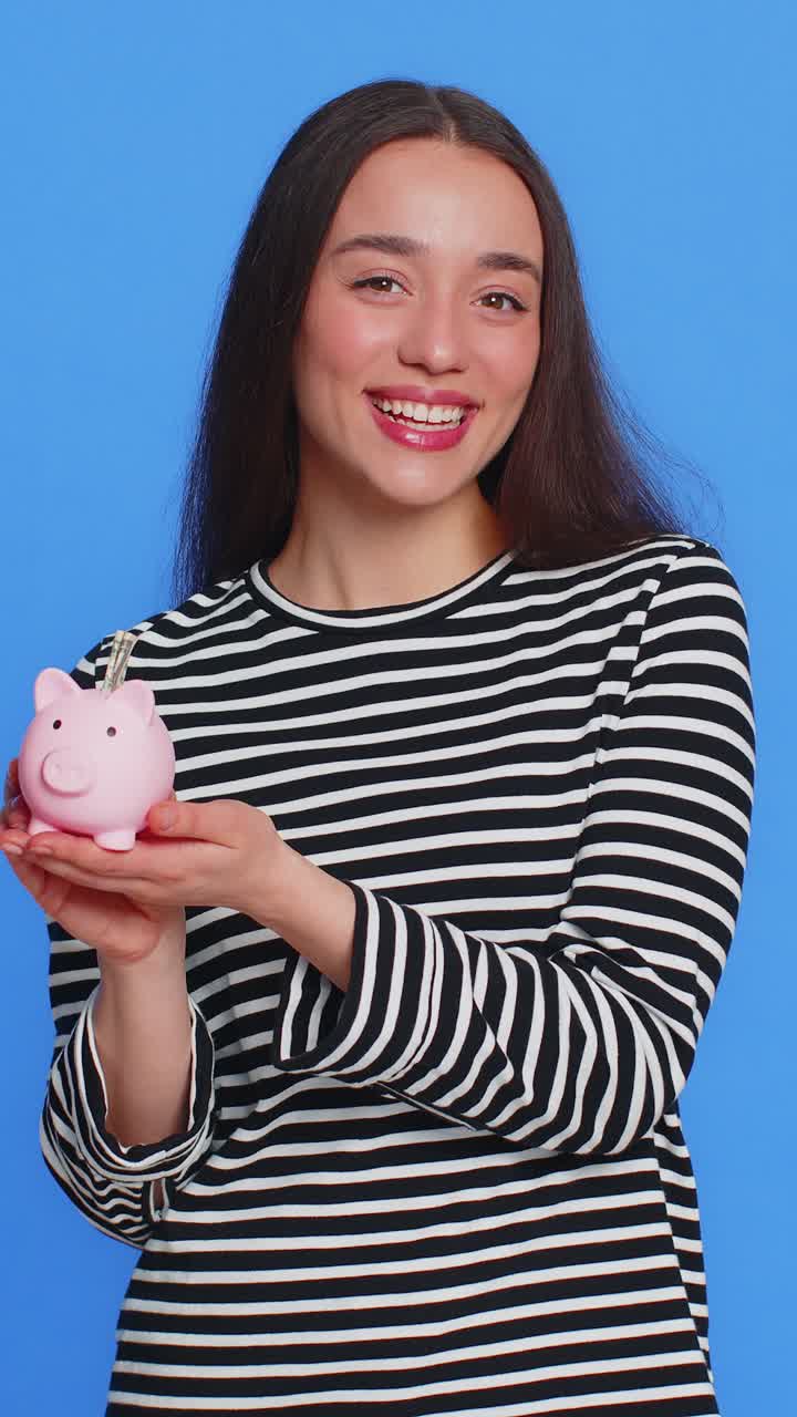 Happy rich woman puts money dollar pocket cash into piggy bank saving finance income growth salary
