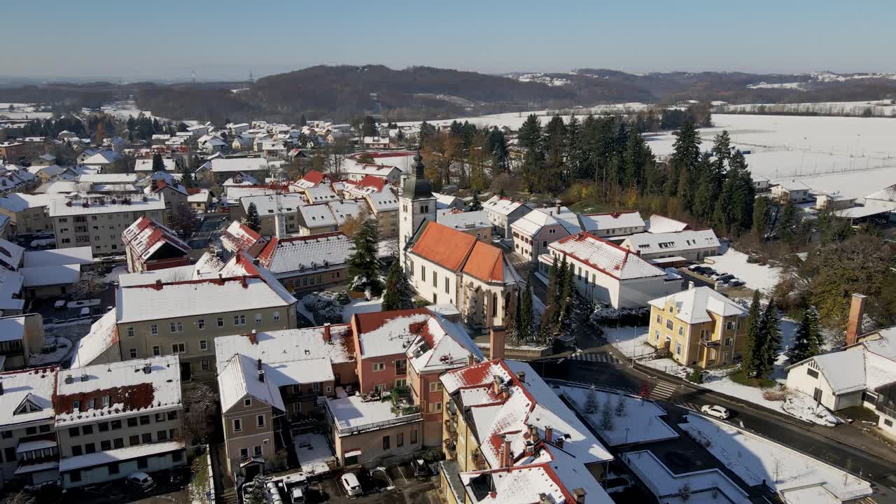Pohled dronu na centrum města Ormož a kostel se zasněženými střechami ve Slovinsku.