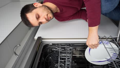 Man-nods-approvingly-at-a-clean-plate-from-a-dishwasher