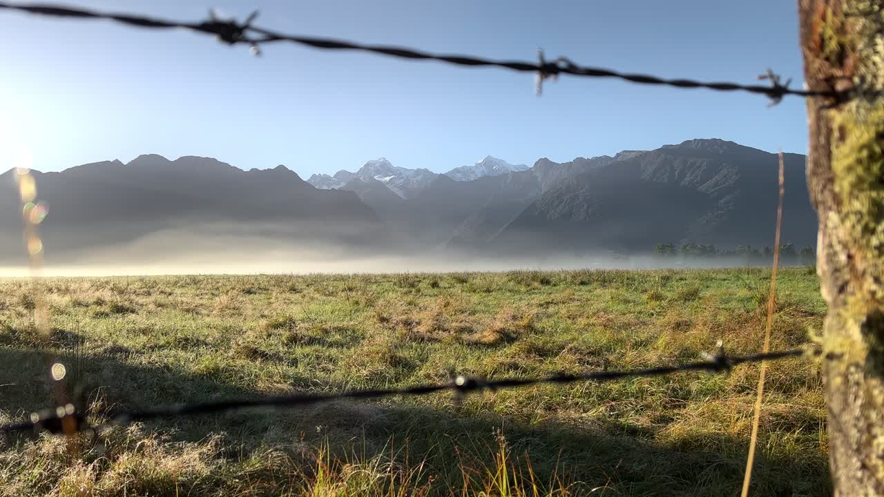picos nevados de mt cook y mt tasman, nueva zelanda con una valla de alambre de púas en primer plano