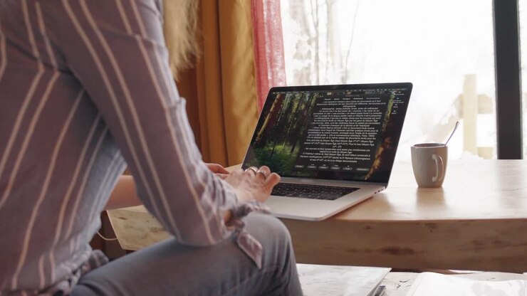 Professional working on laptop in modern workspace, symbolizing focus, productivity, and contemporary work culture. Warm, natural light enhances the productive atmosphere.