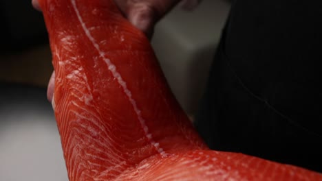 salmón crudo en la mano del chef