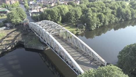 Órbita-Aérea-Vista-Izquierda-Escénica-Antigua-Arcada-De-Acero-Vintage-Tráfico-Pasarela-Sobre-El-Cruce-Del-Canal-De-Barcos-De-Manchester