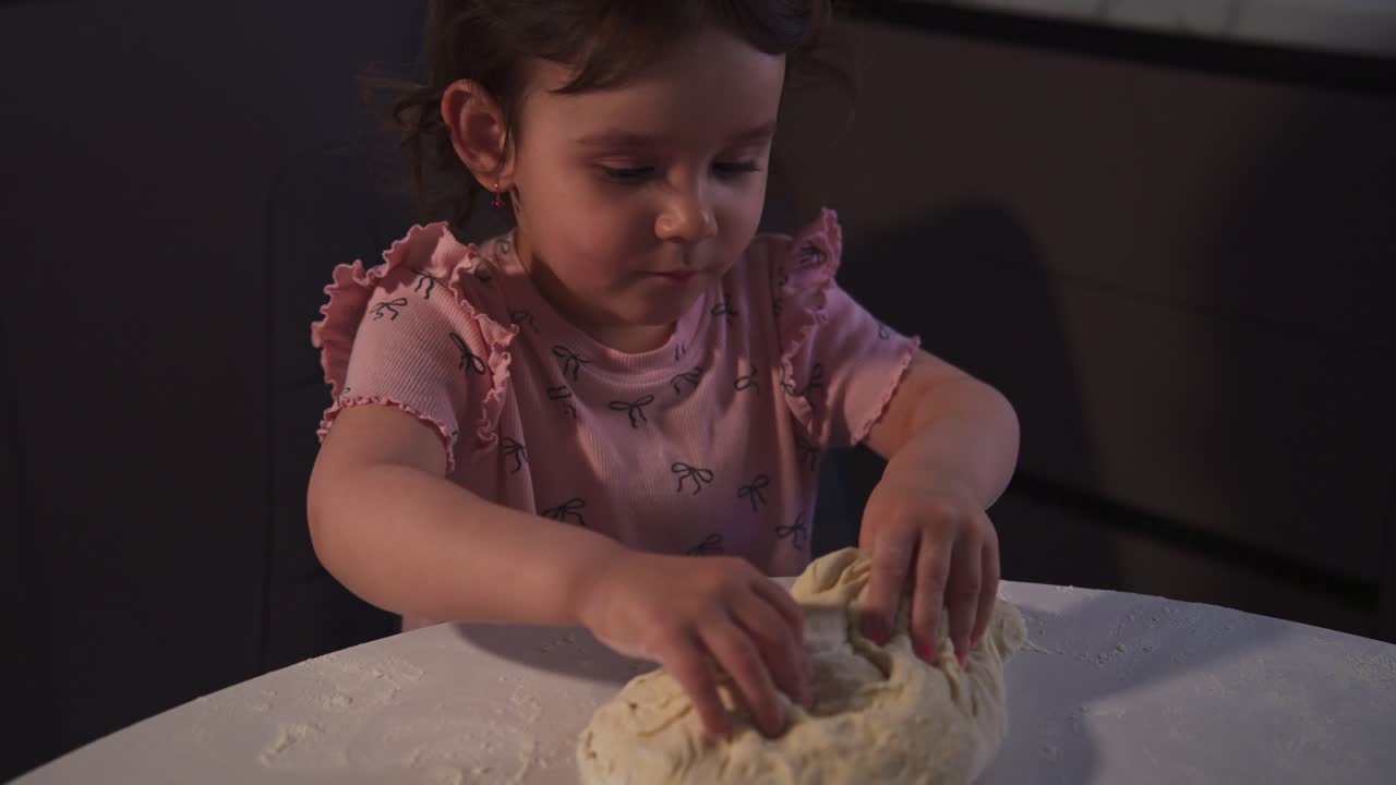 Little Girl Kneading Dough on a Floured Table