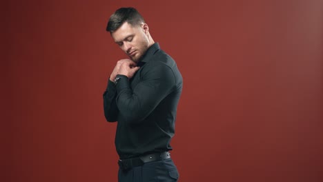 handsome man with strong body in a dark shirt preparing and having look at the camera. half waist view video.