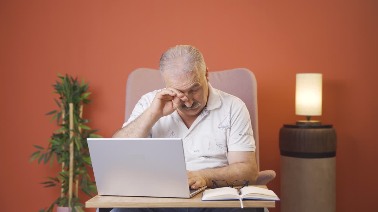 un viejo cansado en la computadora portátil.
