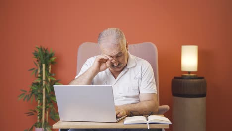 un viejo cansado en la computadora portátil.