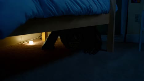 creepy figure hiding under bed at night