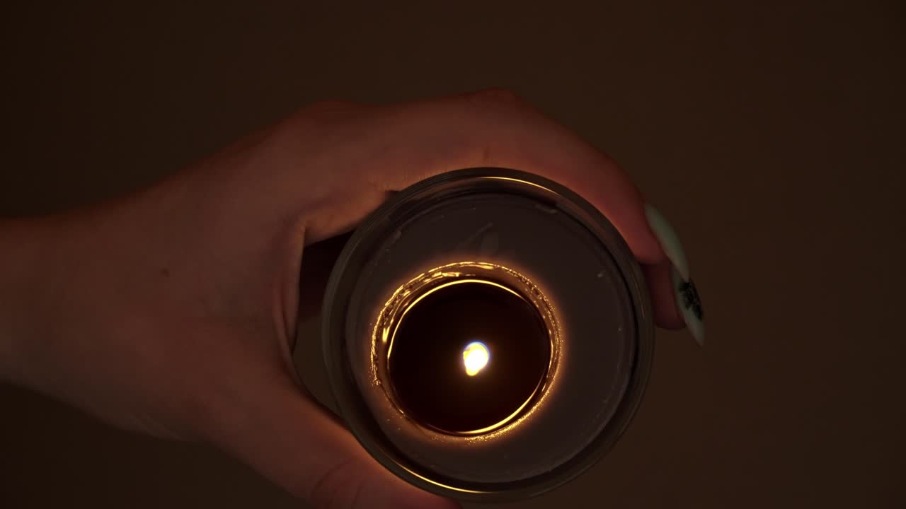 Candle Burns Atmospherically in the Hands of a Girl with a Beautiful Manicure