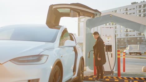hombre cargando un vehículo eléctrico en una estación de carga