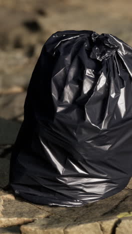 close-up of a black garbage bag on the ground