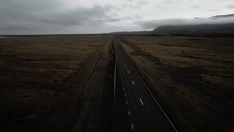 cinematic aerial empty road, rocky volcanic mountain nature, epic moody dark landscape scenery iceland