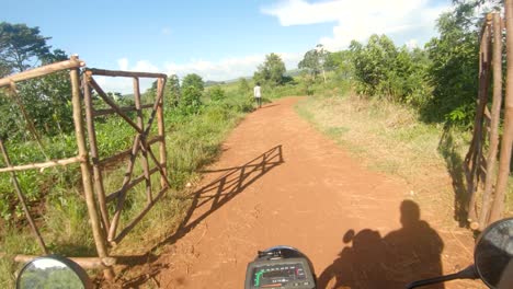 Point-of-view-shot-of-a-white-man-holding-onto-a-motor-bikes-handle-bars-and-riding-through-rural-Africa