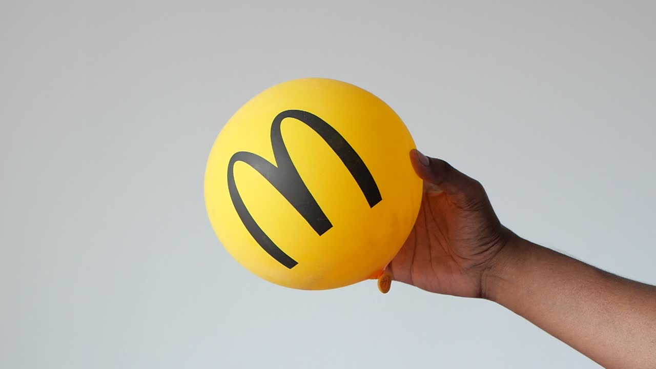 persona que sostiene un globo amarillo de mcdonald