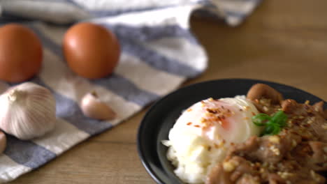 cerdo salteado con ajo sobre arroz cubierto con huevo - estilo de comida asiática