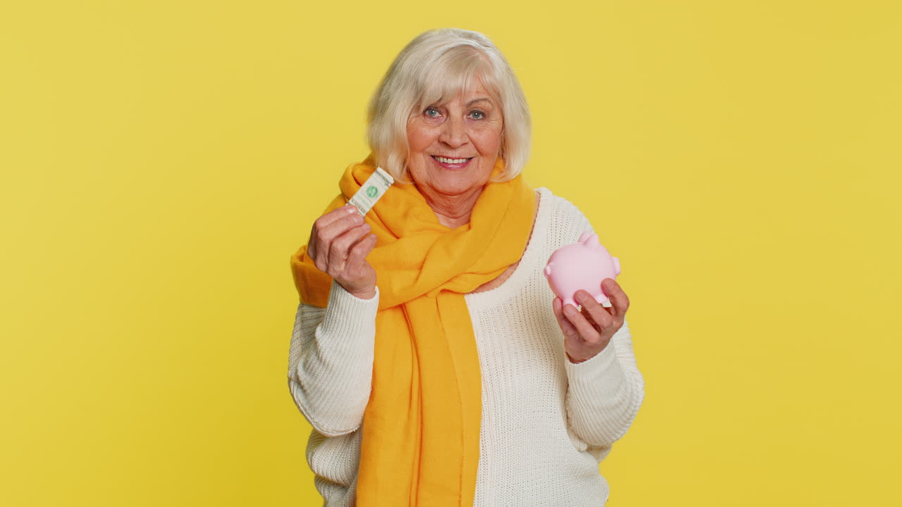 Senior rich old woman putting dollar pocket money cash into piggy bank saving for future needs