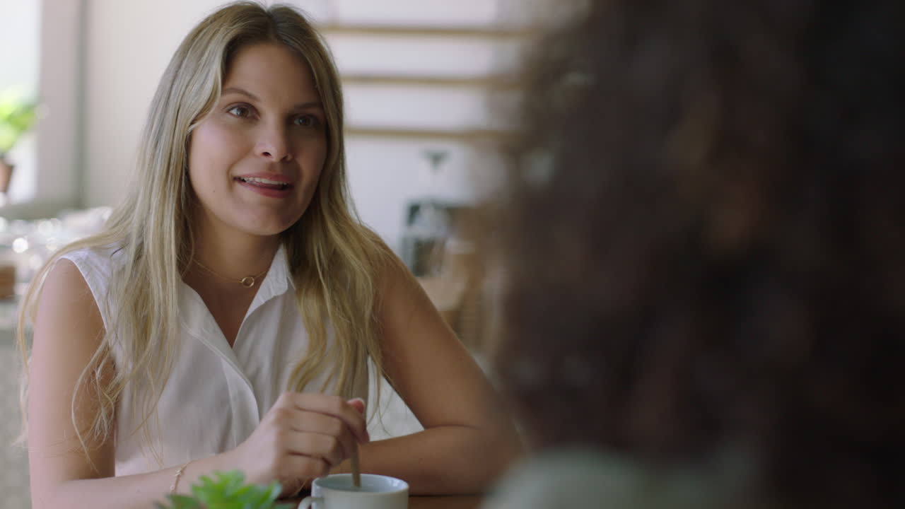 bella donna in un caffè che parla con un'amica che beve caffè che si gode una conversazione rilassata che chiacchiera insieme che socializza in un ristorante
