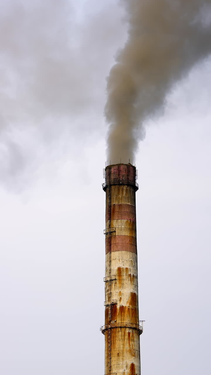 Old pipes with massive smoke in the sky. Dangerous emissions going up in the air. Pollution of the environment. Ecological problems. Vertical video