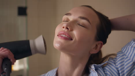 happy girl drying hair in home bathroom closeup. carefree model dancing evening