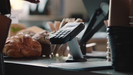 cliente de cerca usando reloj inteligente haciendo pago sin contacto transferencia de dinero móvil en un café disfrutando del servicio en un restaurante cafetería